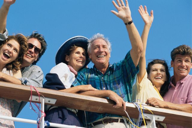 Couple waving goodbye from a cruise ship